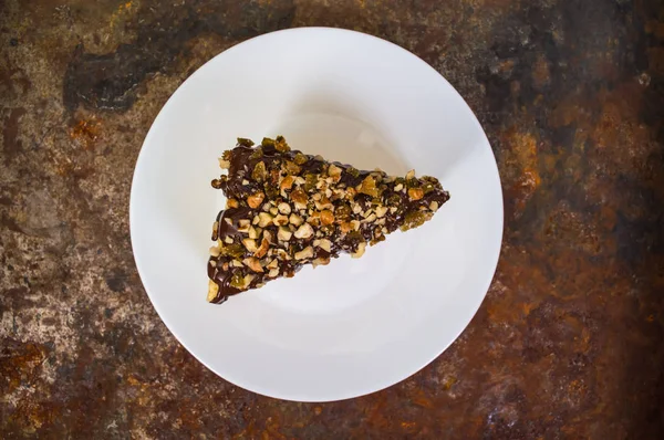 古いテーブルにチョコレートとクルミ レーズンで覆われたナポレオン ケーキ。平面図です。クローズ アップ — ストック写真