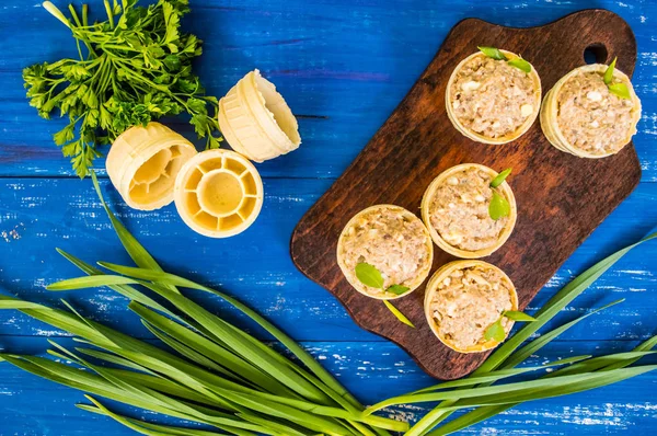 Balık ve yeşillik bir ahşap mavi zemin üzerine pate tartlets. Üstten Görünüm. Yakın çekim — Stok fotoğraf