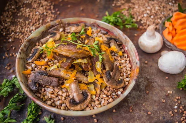 Porridge di grano saraceno con carne e funghi sul vecchio tavolo. Vista dall'alto. Primo piano — Foto Stock