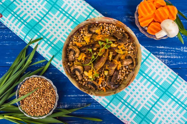 Porridge di grano saraceno con carne e funghi su sfondo rustico in legno. Vista dall'alto. Primo piano — Foto Stock