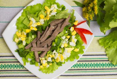 Karaciğer, yumurta, marul ve yeşil soğan salatası. Ahşap arka plan. Üstten Görünüm. Yakın çekim