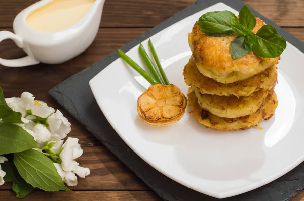 Panqueques de patata con salsa de crema agria en el color de fondo. Mesa de madera. Primer plano —  Fotos de Stock