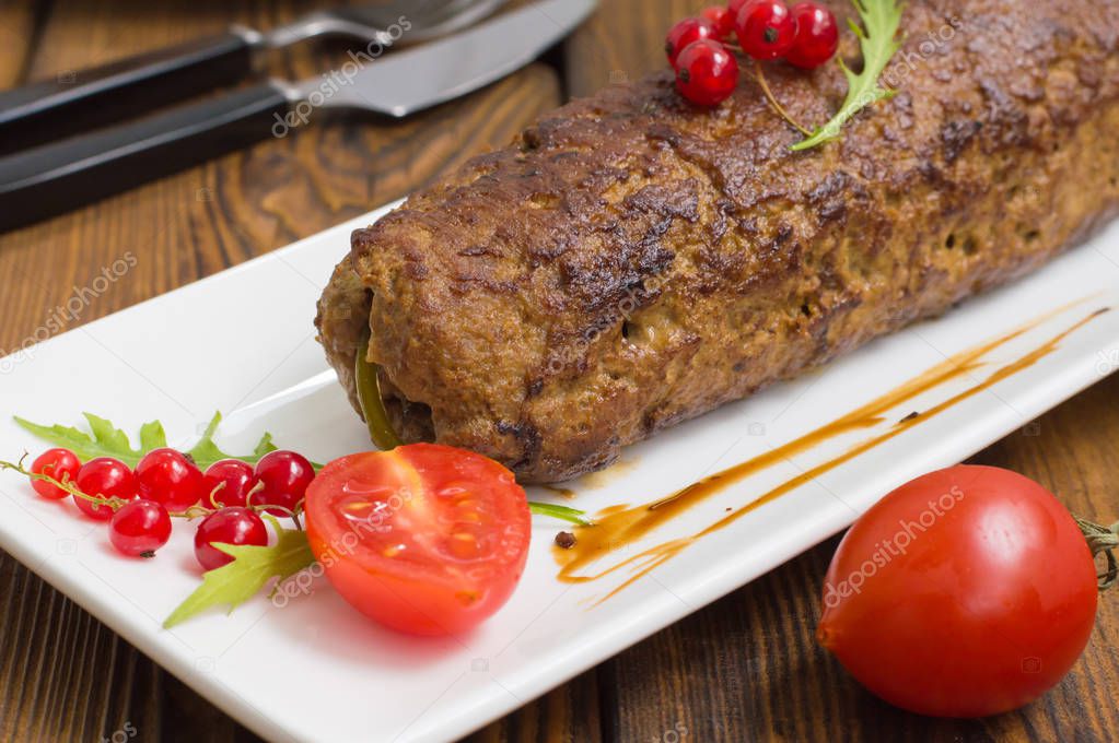 Meatloaf stuffed with mushrooms  sauce and berries. Wooden rustic background. Close-up