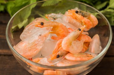 Şeffaf bir plaka buz dondurulmuş çiğ karides. Ahşap arka plan. Üstten Görünüm. Yakın çekim