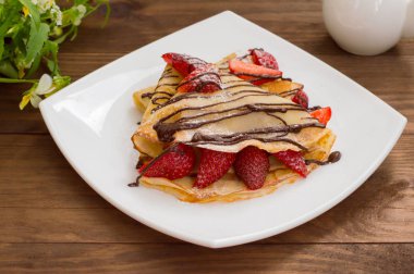 Krep çikolata çilek ile tepesinde. Ahşap masa. Üstten Görünüm