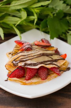 Krep çikolata çilek ile tepesinde. Ahşap masa. Üstten Görünüm