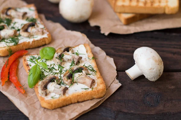 Smörgåsar bestående av toast med stekt grillad svamp och smält ost kryddor. Svarta träbord. Närbild — Stockfoto