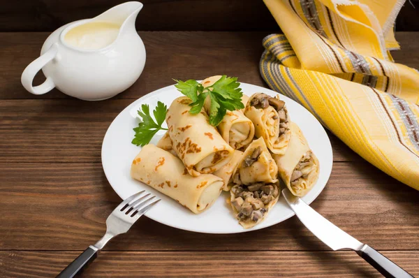 Frittelle ripiene di funghi e panna acida su un tavolo di legno rustico. Vista dall'alto. Primo piano — Foto Stock