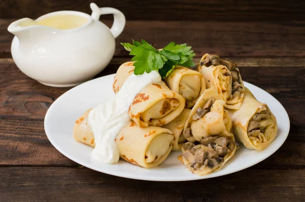 Pancakes stuffed with mushrooms and sour cream on a rustic wooden table. Top view. Close-up — Stock Photo, Image