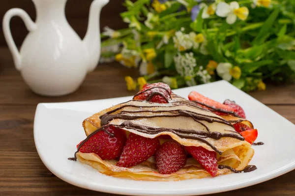 Pancakes with strawberries, topped  chocolate. Wooden table. Top view — Stock Photo, Image