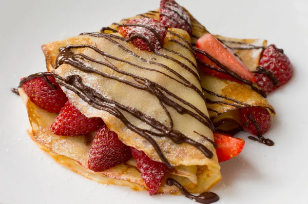 Pfannkuchen mit Erdbeeren, gekrönt chocolate.white Hintergrund. Ansicht von oben — Stockfoto