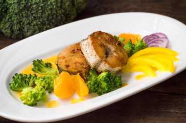 Lezzetli fileto balık kızartma tavada kavrulmuş. Mandalina sosu, biber ve Haşlanmış brokoli dilim al dente gönderildi. Ahşap arka plan. Üstten Görünüm. Yakın çekim