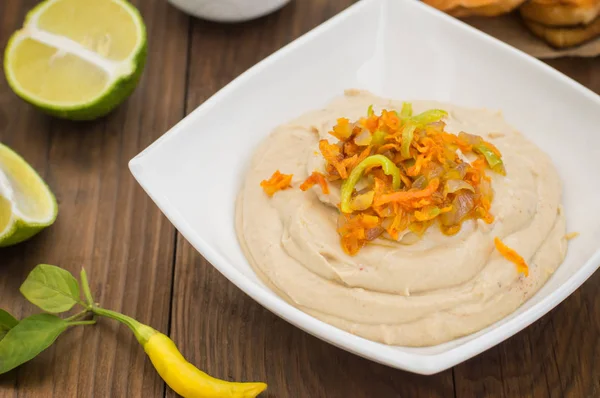 Hummus - puree van kikkererwten voorgerecht, gewoonlijk samengesteld bestaat uit olijfolie met knoflook, citroensap, paprikapoeder, sesam plakken. — Stockfoto