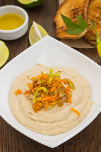 Hummus - puree van kikkererwten voorgerecht, gewoonlijk samengesteld bestaat uit olijfolie met knoflook, citroensap, paprikapoeder, sesam plakken. — Stockfoto