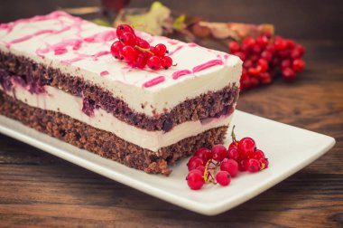 Kiraz kek krem ve kırmızı kuş üzümü ile. Ahşap arka plan. Üstten Görünüm. Yakın çekim