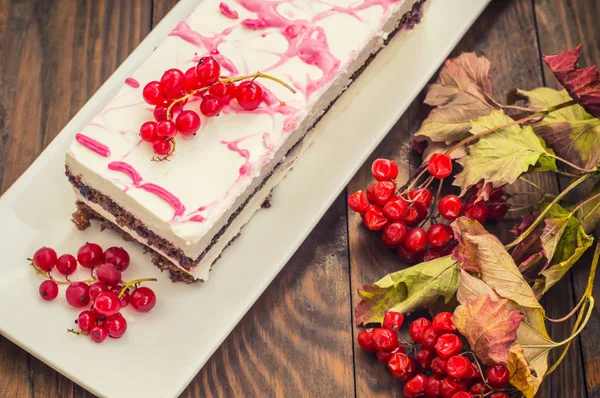 Kiraz kek krem ve kırmızı kuş üzümü ile. Ahşap arka plan. Üstten Görünüm. Yakın çekim