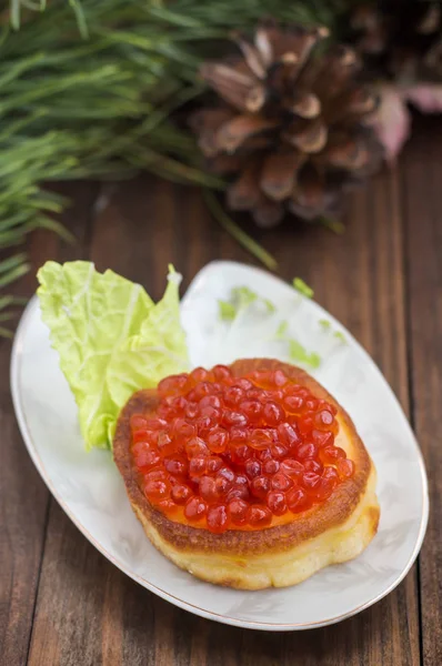 sağlıklı meze: beyaz Çin plaka üzerinde kırmızı havyar ile sandviç. Ahşap arka plan. Üstten Görünüm. Yakın çekim