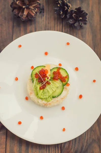 Healthy appetizer : sandwich with sea salmon and red caviar on white china plate. Wooden background. Top view — Stock Photo, Image