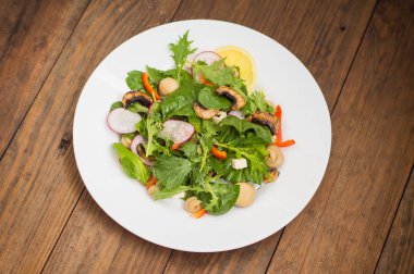 Turp, Mizuno, taze bahar salatası mantar ızgara, Adygei peynir, ıspanak, biber, limon, Mısır. Ahşap arka plan