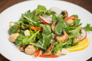 Turp, Mizuno, taze bahar salatası mantar ızgara, Adygei peynir, ıspanak, biber, limon, Mısır. Ahşap arka plan