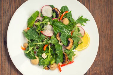 Turp, Mizuno, taze bahar salatası mantar ızgara, Adygei peynir, ıspanak, biber, limon, Mısır. Ahşap arka plan