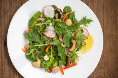 Turp, Mizuno, taze bahar salatası mantar ızgara, Adygei peynir, ıspanak, biber, limon, Mısır. Ahşap arka plan