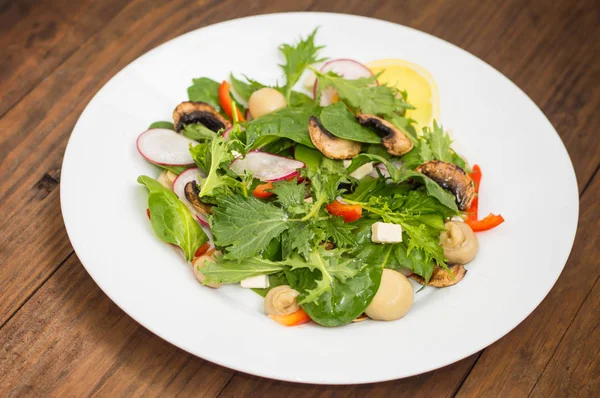 Salad musim semi segar dengan lobak, Mizuno, jamur panggang, keju Adygei, bayam, paprika, lemon, jagung. Latar belakang kayu — Stok Foto