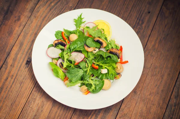 Ensalada de primavera fresca con rábano, Mizuno, champiñones a la parrilla, queso Adygei, espinacas, pimiento, limón, maíz. Fondo de madera —  Fotos de Stock