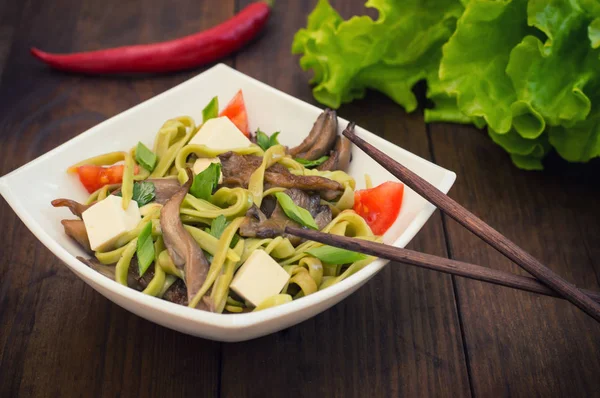 Piatto di pasta di spaghetti con spinaci e funghi ostrica. Cucina italiana, ricette italiane. Sfondo in legno. Vista dall'alto. Primo piano — Foto Stock