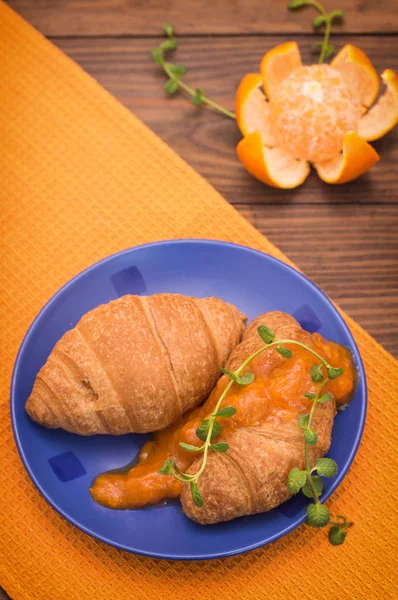 Pomerančová marmeláda a croissanty k snídani. Dřevěné pozadí. Pohled shora. Detail — Stock fotografie
