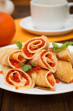 Rulo krep kırmızı havyar ile. Rus yemekleri. Düz yatıyordu. Maslenitsa. Ahşap arka plan. Üstten Görünüm. Yakın çekim