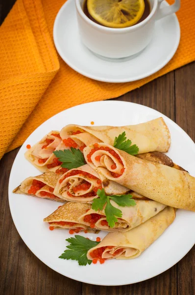 Rulo krep kırmızı havyar ile. Rus yemekleri. Düz yatıyordu. Maslenitsa. Ahşap arka plan. Üstten Görünüm. Yakın çekim