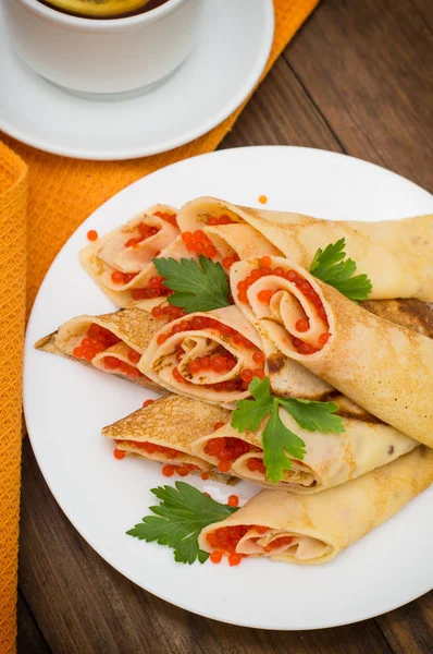 Rulo krep kırmızı havyar ile. Rus yemekleri. Düz yatıyordu. Maslenitsa. Ahşap arka plan. Üstten Görünüm. Yakın çekim