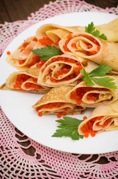 Rulo krep kırmızı havyar ile. Rus yemekleri. Düz yatıyordu. Maslenitsa. Ahşap arka plan. Üstten Görünüm. Yakın çekim