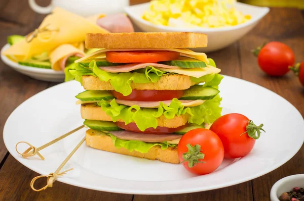 大きなサンドイッチ、肉、レタス、チーズ、野菜のトースト。木製の背景。クローズ アップ — ストック写真