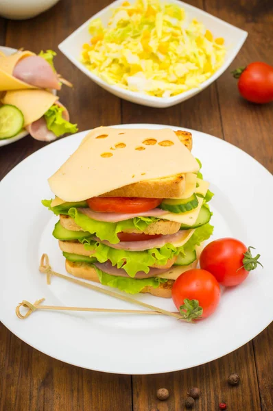 Panino grosso, carne, lattuga, formaggio e verdure tostate. Sfondo in legno. Primo piano — Foto Stock