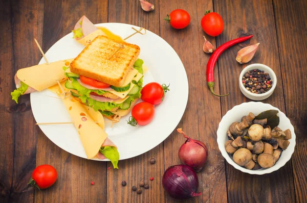 Stor smörgås, kött, sallad, ost och grönsaker på rostat. Trä bakgrund. Ovanifrån. Närbild — Stockfoto