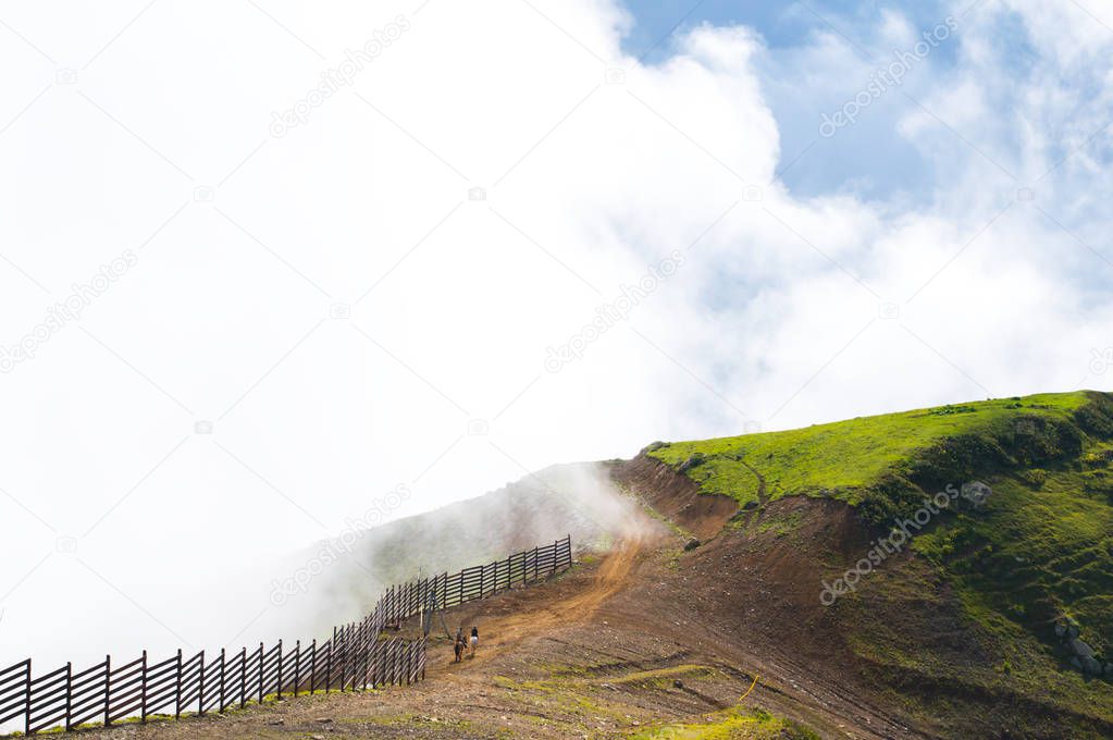 Beautiful mountain scenery. Summer in the mountains. People ride horses in the mountains at high altitude. Landscape. Sochi. Russia. Rosa Khutor