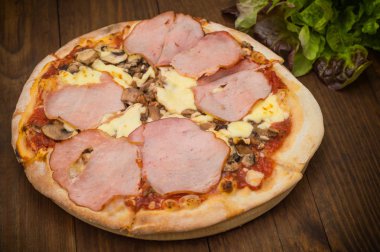 Pizza domuz jambon, mantar ve sosis. Ahşap arka plan. Üstten görünüm. Yakın çekim