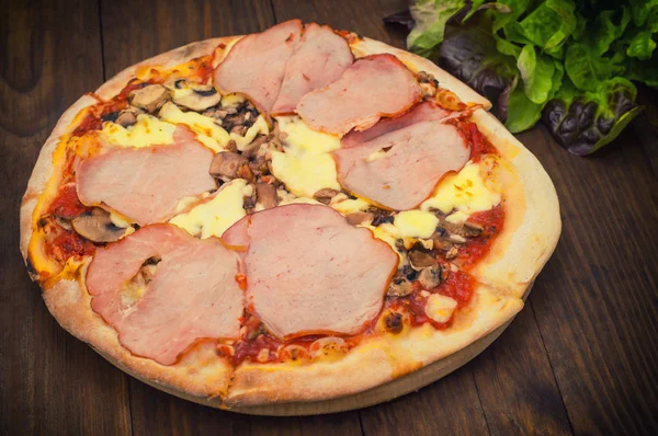 Pizza com presunto de bacon, cogumelos e salsicha. Fundo de madeira. Vista superior. Close-up — Fotografia de Stock