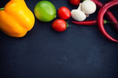 Farklı sebze siyah bir taş zemin üzerine. Üstten Görünüm