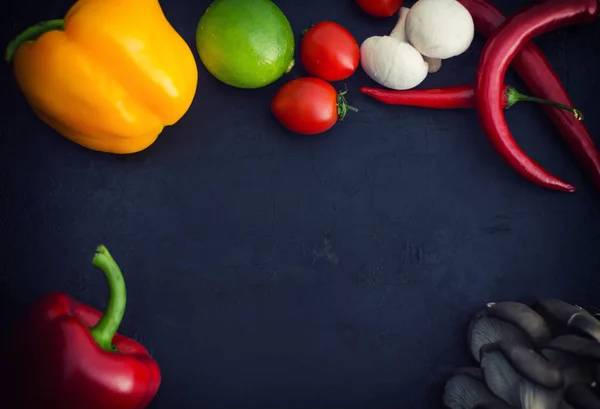 Legumes diferentes em um fundo de pedra preta. Vista superior — Fotografia de Stock