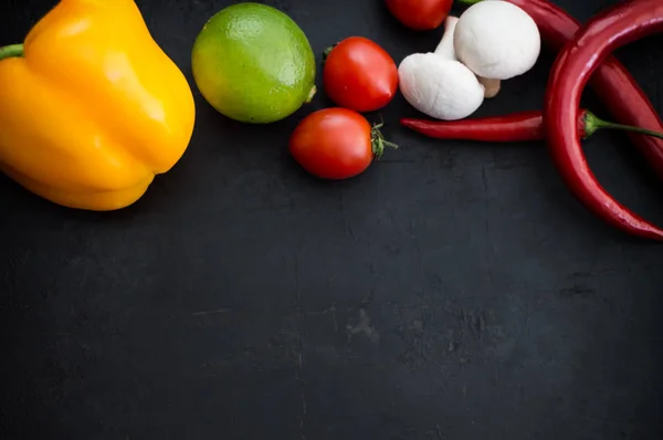 Legumes diferentes em um fundo de pedra preta. Vista superior — Fotografia de Stock