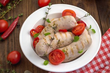 Kiraz domates ve biber yeşillikleri ile ızgara sosis haşlama. Ahşap arka plan. Üstten Görünüm. Yakın çekim