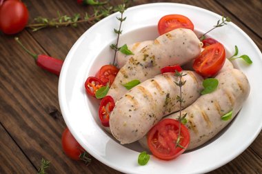 Kiraz domates ve biber yeşillikleri ile ızgara sosis haşlama. Ahşap arka plan. Üstten Görünüm. Yakın çekim