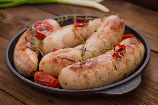 Saucisses grillées dans une poêle. Fond en bois. Vue de dessus. Gros plan — Photo