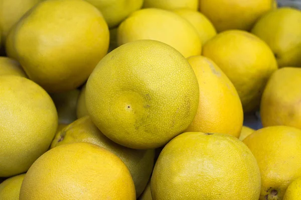 Érett grapefruit, sárga, eladásra a piacon. Hátteret. Felülnézet. Közeli kép: — Stock Fotó