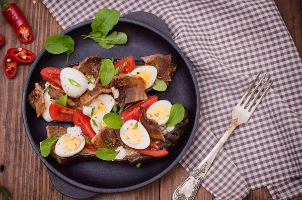 Bakad aubergine med bacon, vitlök och vaktel ägg på pannan. Trä bakgrund. Ovanifrån. Närbild — Stockfoto