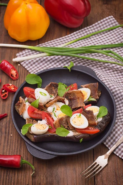 Bakad aubergine med bacon, vitlök och vaktel ägg på pannan. Trä bakgrund. Ovanifrån. Närbild — Stockfoto