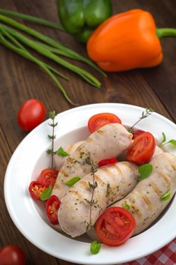 Kiraz domates ve biber yeşillikleri ile ızgara sosis haşlama. Ahşap arka plan. Üstten Görünüm. Yakın çekim